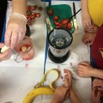 Pre-school children learning how a fruit smoothie is made