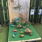 A collection of dinosaur toys in the outdoor area of Harbour Bears Pre-School Larne