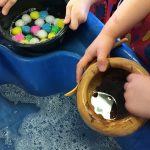 Wooden bowls and pom-poms in the water tray