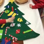 Pre-school children decorating a felt Christmas tree
