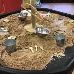 A sand pit with buckets and scoops