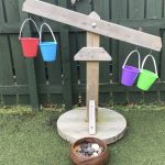 Old-style wooden scales with buckets of different weights placed on each side