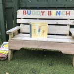 A bench in the garden with a book placed on it