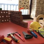 A foam brick walls, hard hat and plastic tools