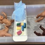 A water tray filled with soapy water, dolls and sponges